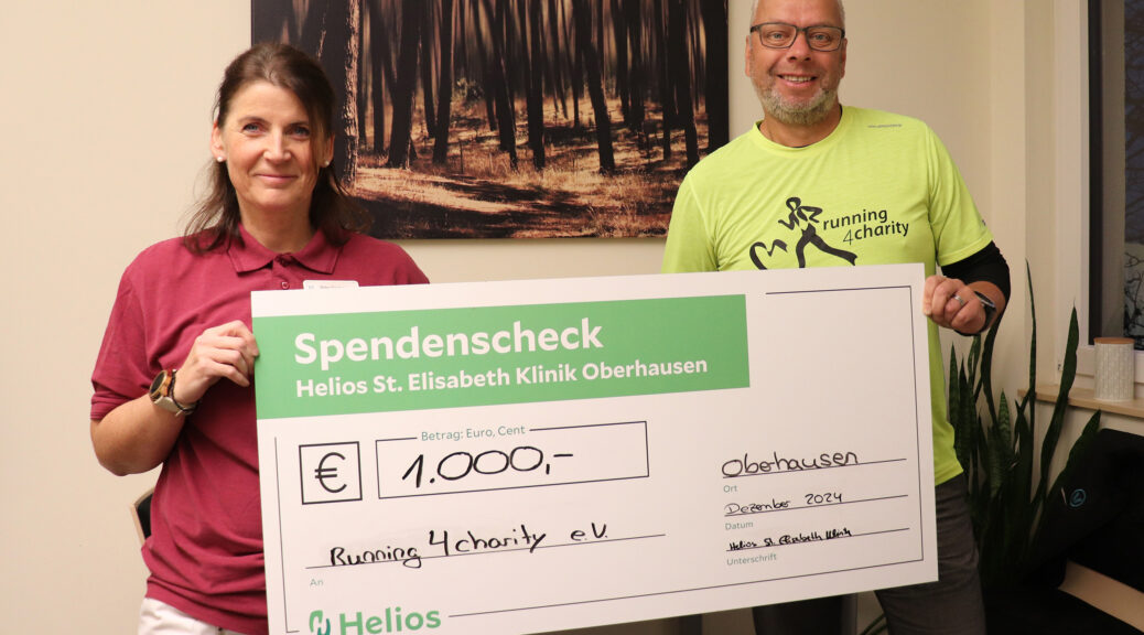 Silke Taubner von der Helios St. Elisabeth Klinik Oberhausen überreicht den Spendenscheck an den Vorsitzenden von running4charity. Diese Helios Oberhausen Spende running4charity würdigt das Engagement des Vereins.