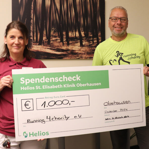 Silke Taubner von der Helios St. Elisabeth Klinik Oberhausen überreicht den Spendenscheck an den Vorsitzenden von running4charity. Diese Helios Oberhausen Spende running4charity würdigt das Engagement des Vereins.