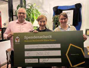 Jörg Marquardt, Sabine Holtkamp und Andrea Wögler halten einen Scheck über die Spende für Ronald McDonald Haus.