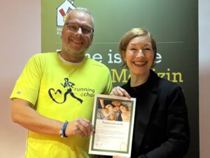 Jörg Marquardt von running4charity übergibt eine Herzenssache Spende kranke Kinder an Sabine Holtkamp vom Ronald McDonald Haus Essen.